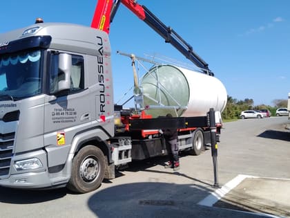 Silo à aliment installé en extérieur le long d'un bâtiment d'élevage