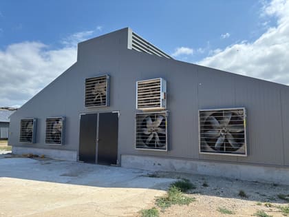 Grilles et turbines de ventilation en façade d'un bâtiment avicole en Bretagne